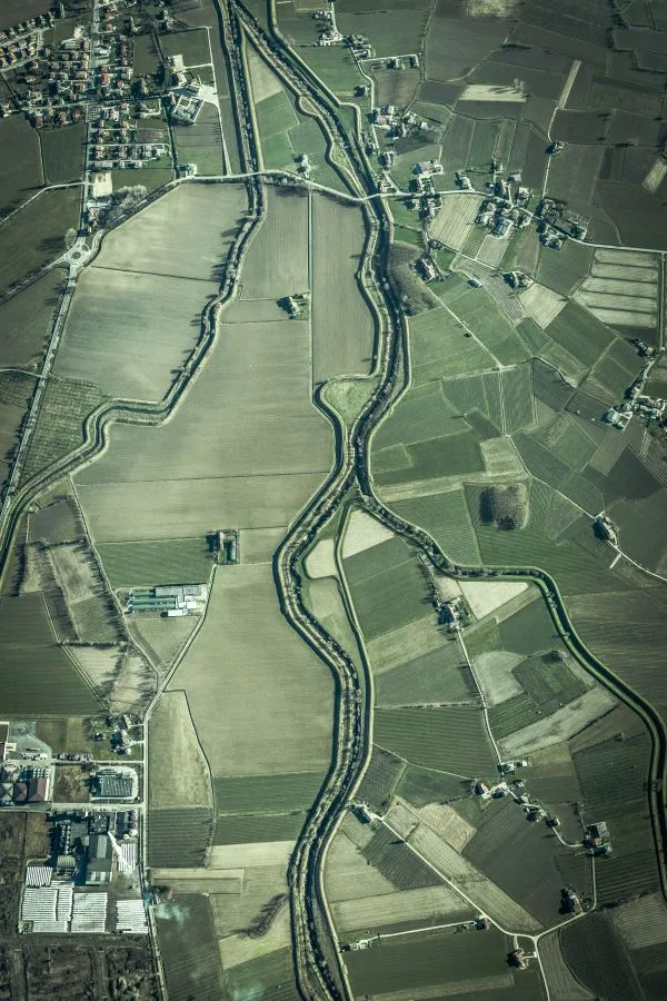 Vista aerea de parcelas agrarias y corredor fluvial en paisaje rural
