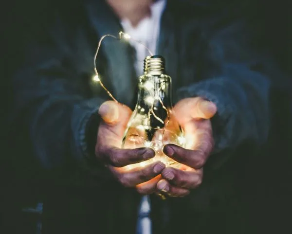Manos sostienen una bombilla con microleds simbolo de idea e innovacion
